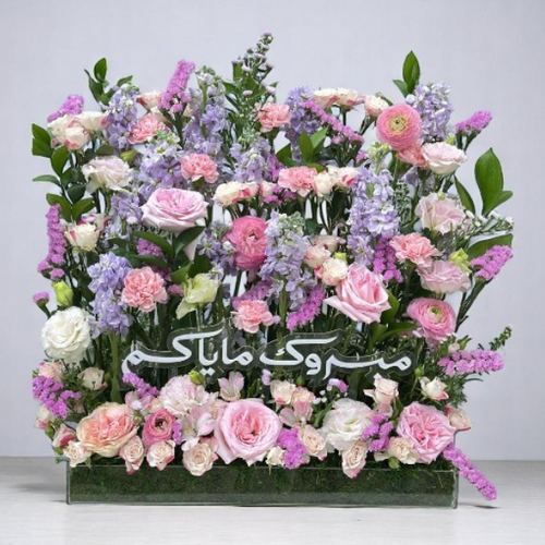 Exquisite floral arrangement with soft pink and purple flowers, perfect for celebrating a newborn baby girl.
