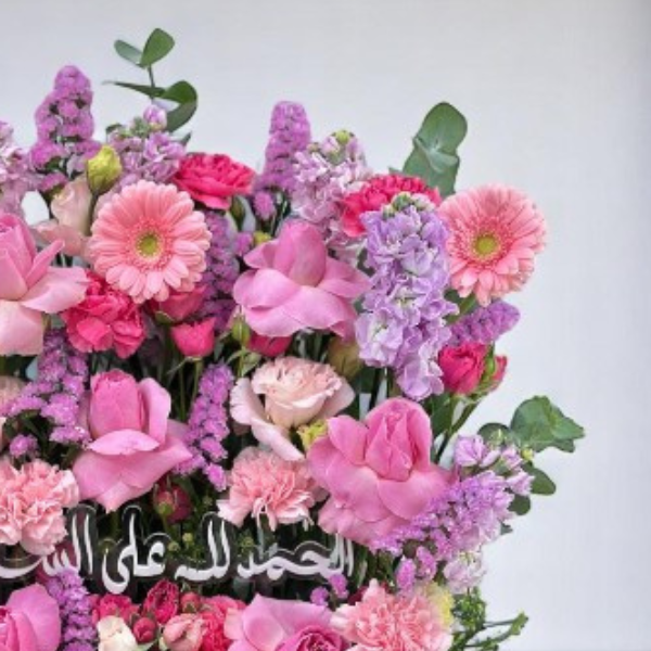 Vibrant fuchsia bouquet with pink and purple flowers celebrating a newborn baby girl