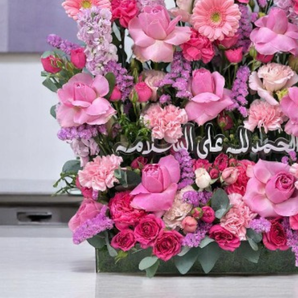 Luxurious fuchsia bouquet featuring pink roses and vibrant flowers, perfect for celebrating a newborn girl.